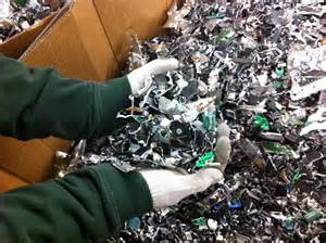 Go-Recyclers / hard drive shredding / computer recycling A person is holding a pile of shredded plastic in their hands.