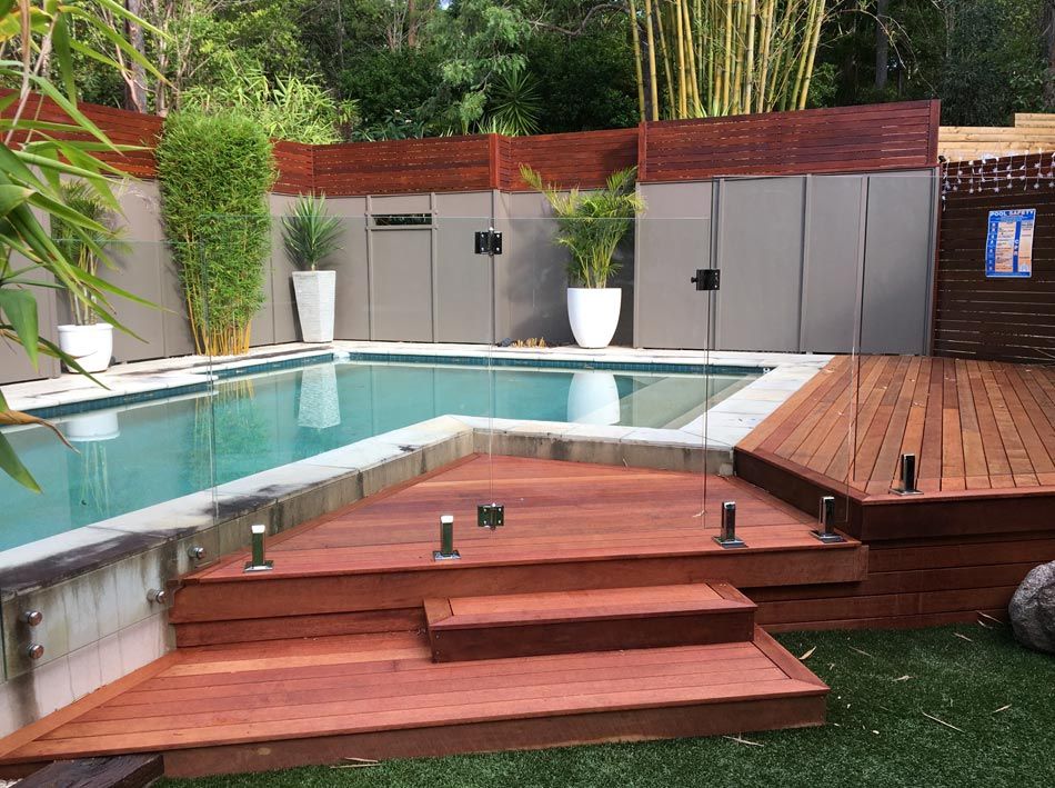 wood deck with stairs next to pool