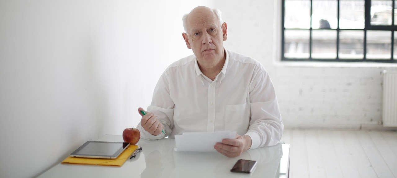 serious-elderly-man-writing-in-papers