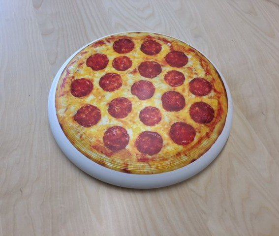 A pepperoni pizza on a white plate on a wooden table