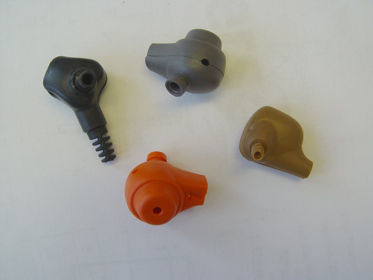 Four different colored plastic objects on a white surface