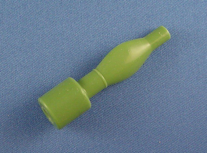 A green plastic object is sitting on a blue surface.