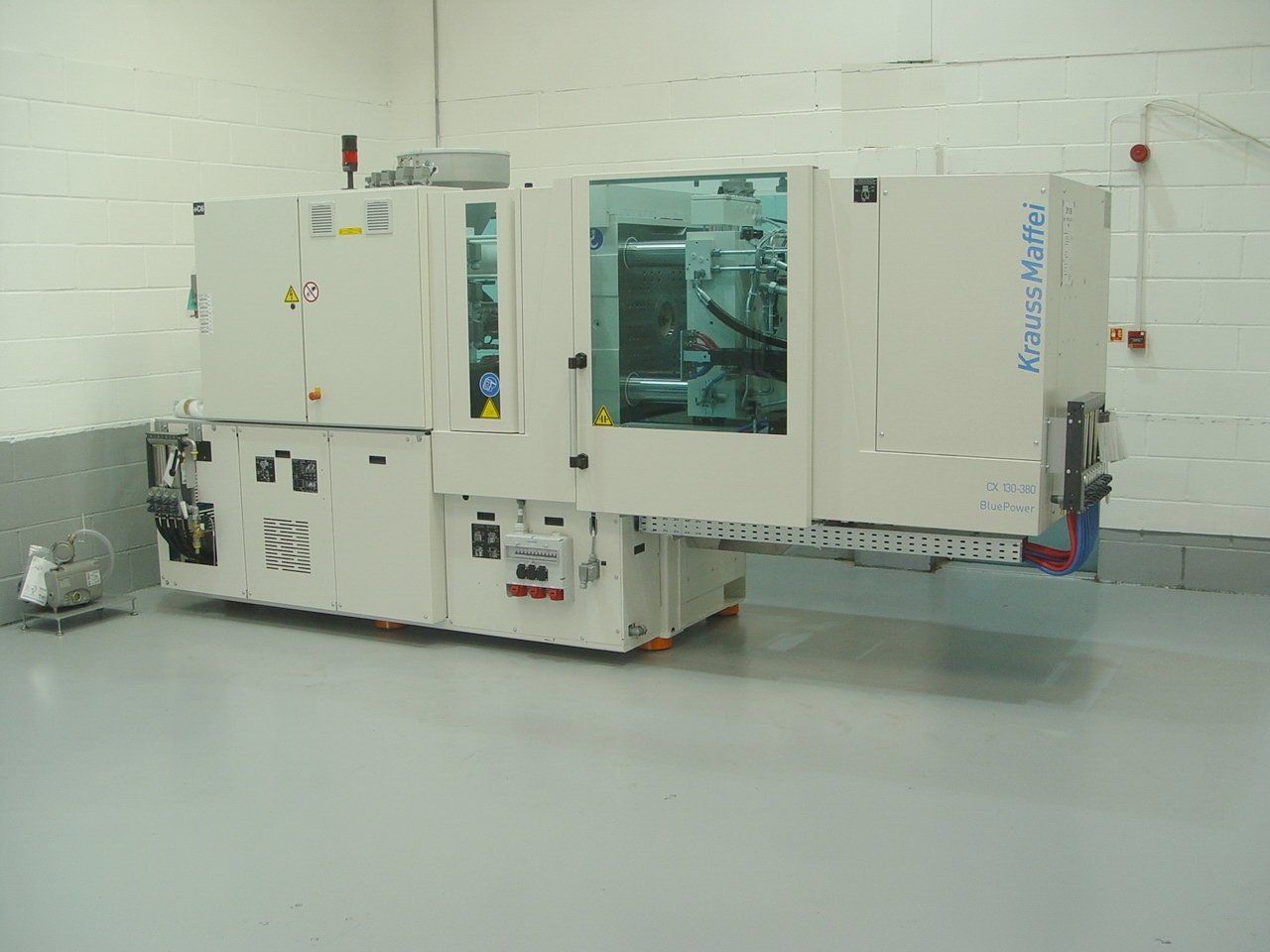 A large machine is sitting in a room next to a wall.