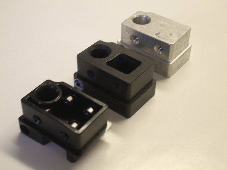 Three pieces of metal are stacked on top of each other on a white surface