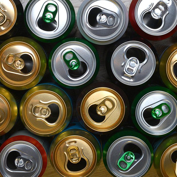 Overhead view of various colorful beverage can tops: green, silver, gold, and red.