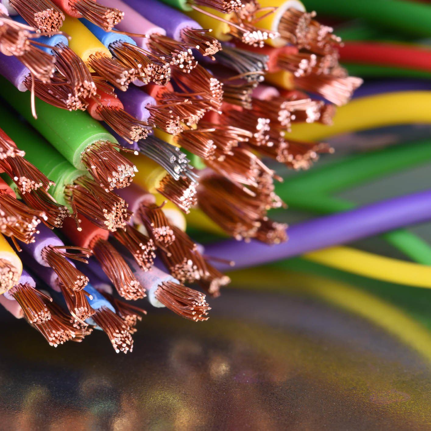 Close-up of a bundle of multicolored electrical wires with exposed copper cores.