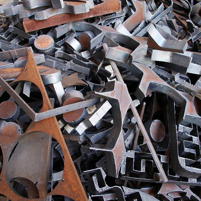 Pile of rusty, cut metal shapes, including circles, triangles, and angled forms.