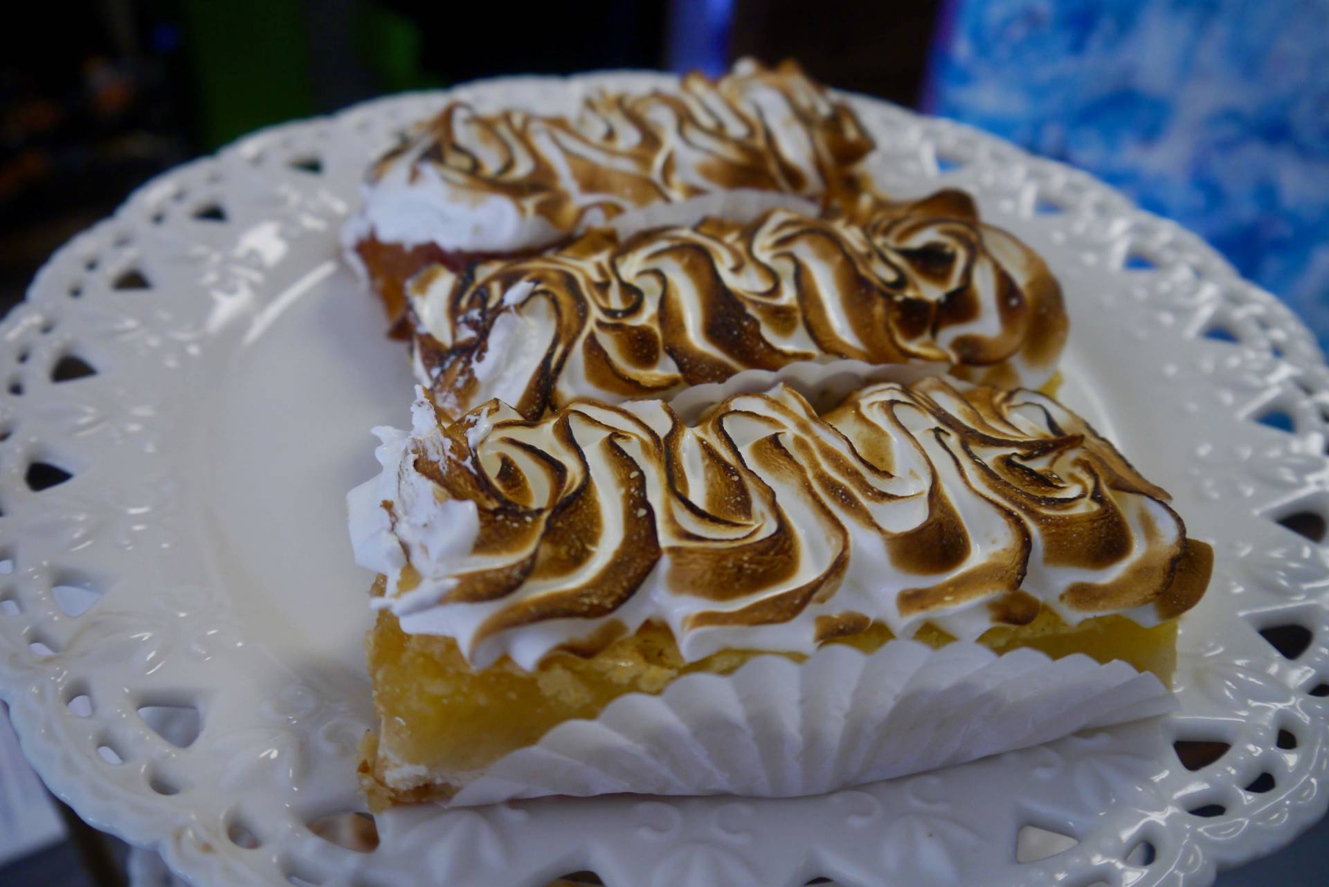 A white plate topped with three pieces of lemon meringue pie.