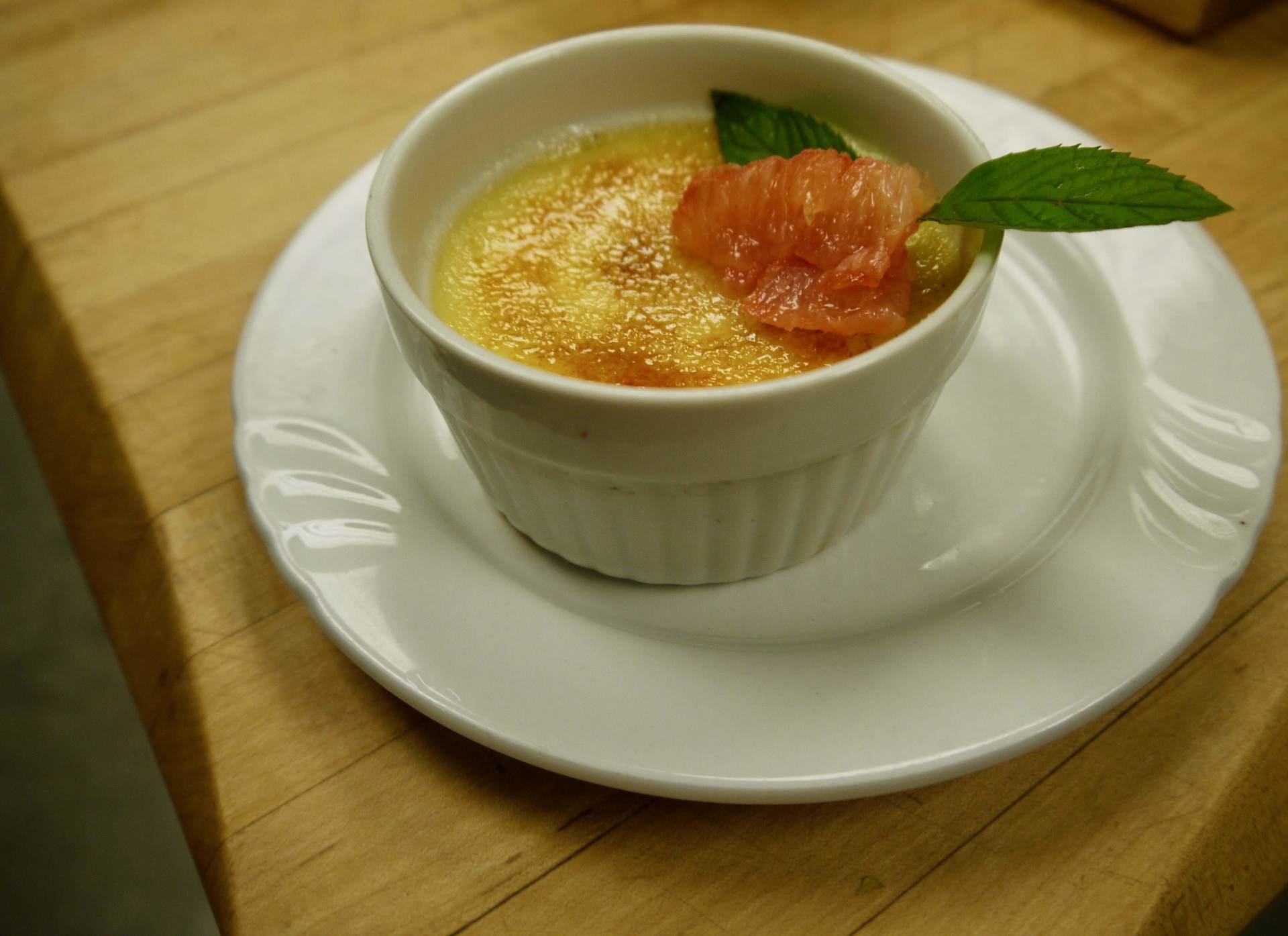 A white plate with a small bowl of food on it