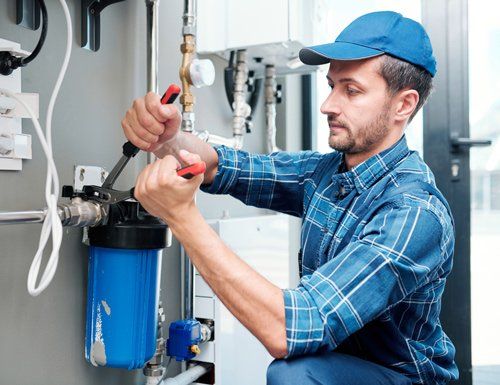 Young Plumber Repairing Water Filtration System — Wimauma, FL — Reedy Plumbing Young Plumber Repairing Water Filtration System — Wimauma, FL — Reedy Plumbing