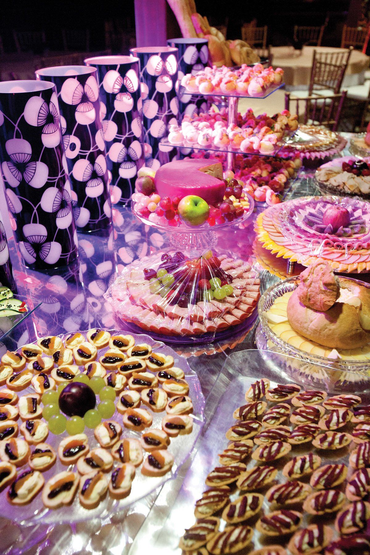 Buffet de sobremesas com uma variedade de bolos, doces e chocolates em uma mesa decorada.