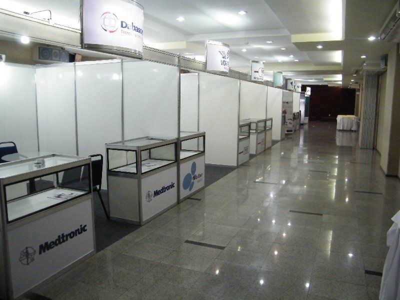 Corredor vazio de shopping center com cabines brancas e piso de azulejo polido.