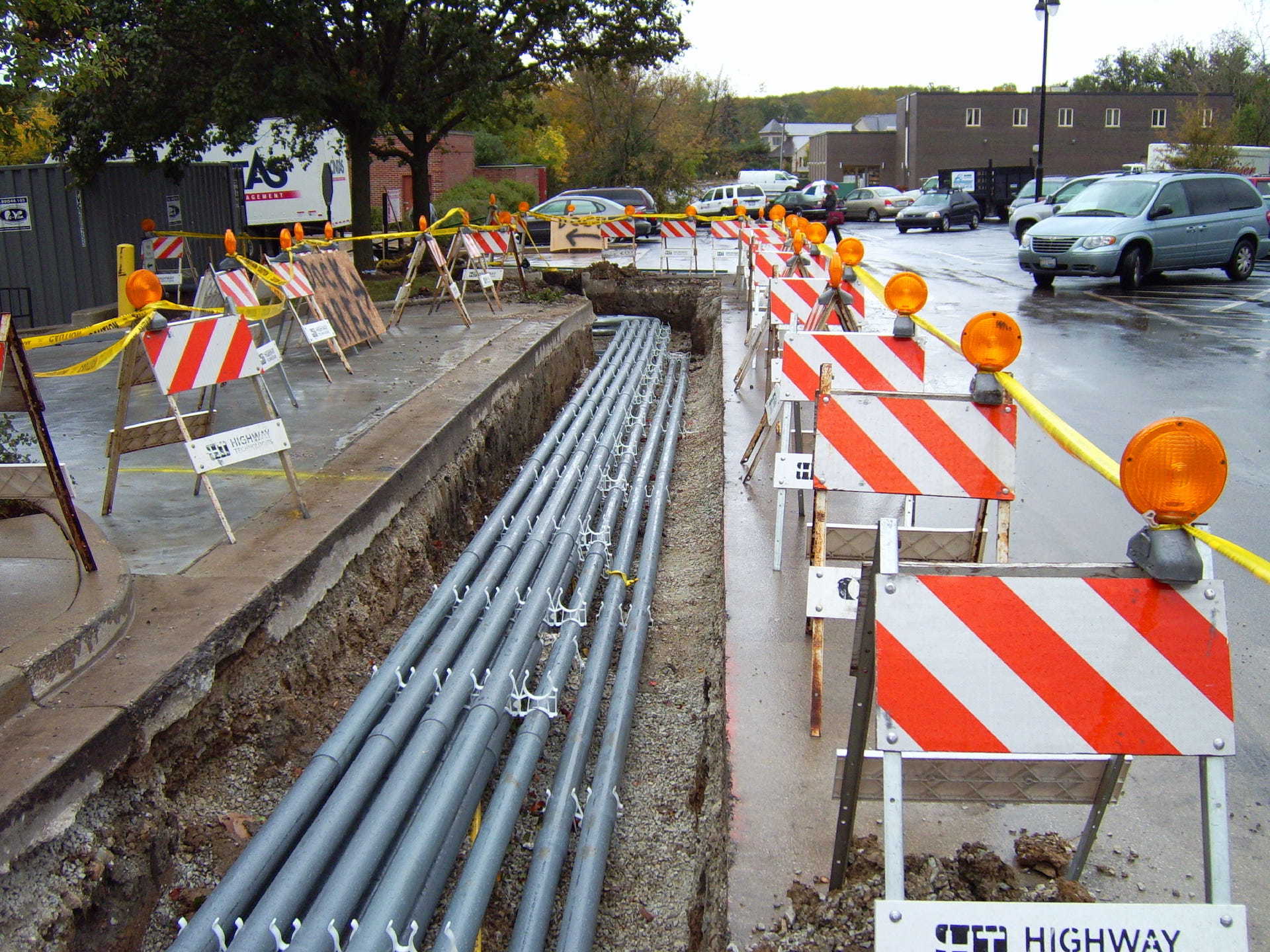 A highway construction site with a bunch of orange and white striped barriers