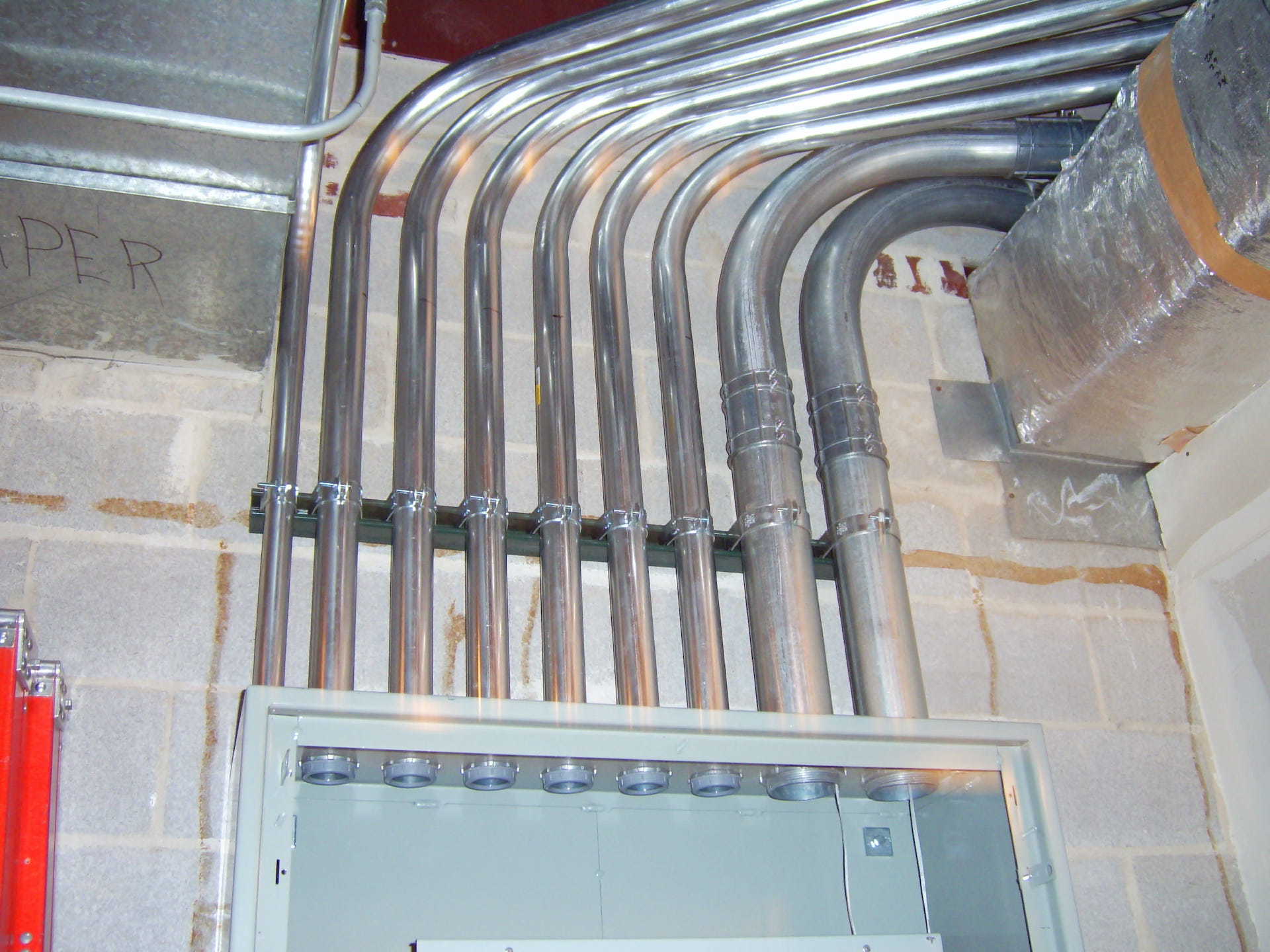 A bunch of metal pipes are hanging from the ceiling