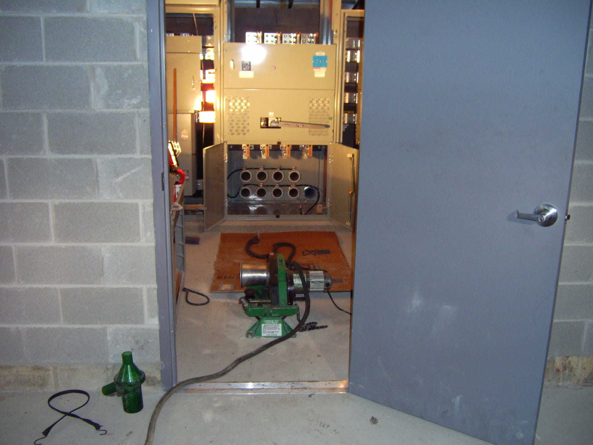 A green machine is sitting in a room with a door open