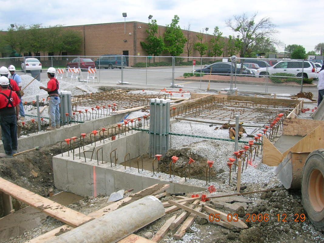 A construction site with a large building in the background