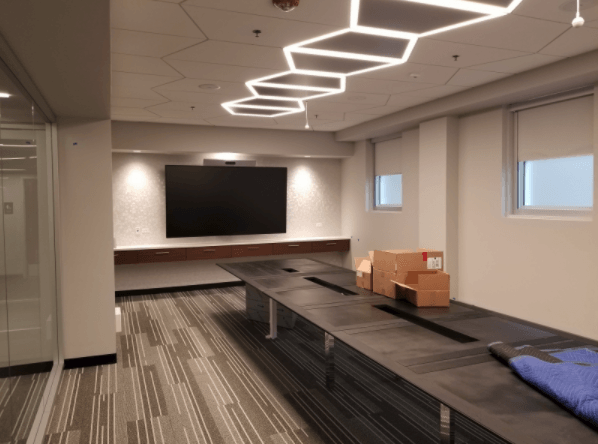 A conference room with a long table and a flat screen tv
