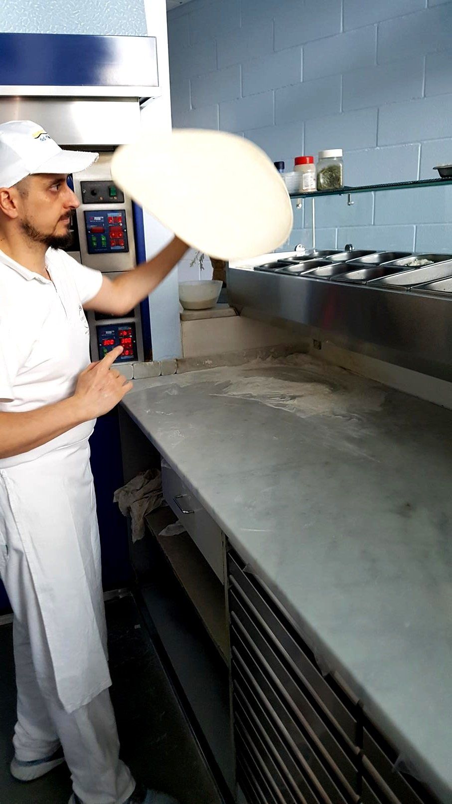 Pizzaiolo fa roteare l'impasto