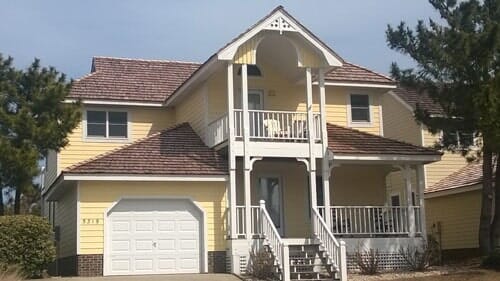 House With Yellow Vinyl Siding And Roof Shingles — Powells Point, NC — Coastal Roofing & Siding Inc