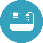 An icon of a bathtub with a shower head and towels in a blue circle.
