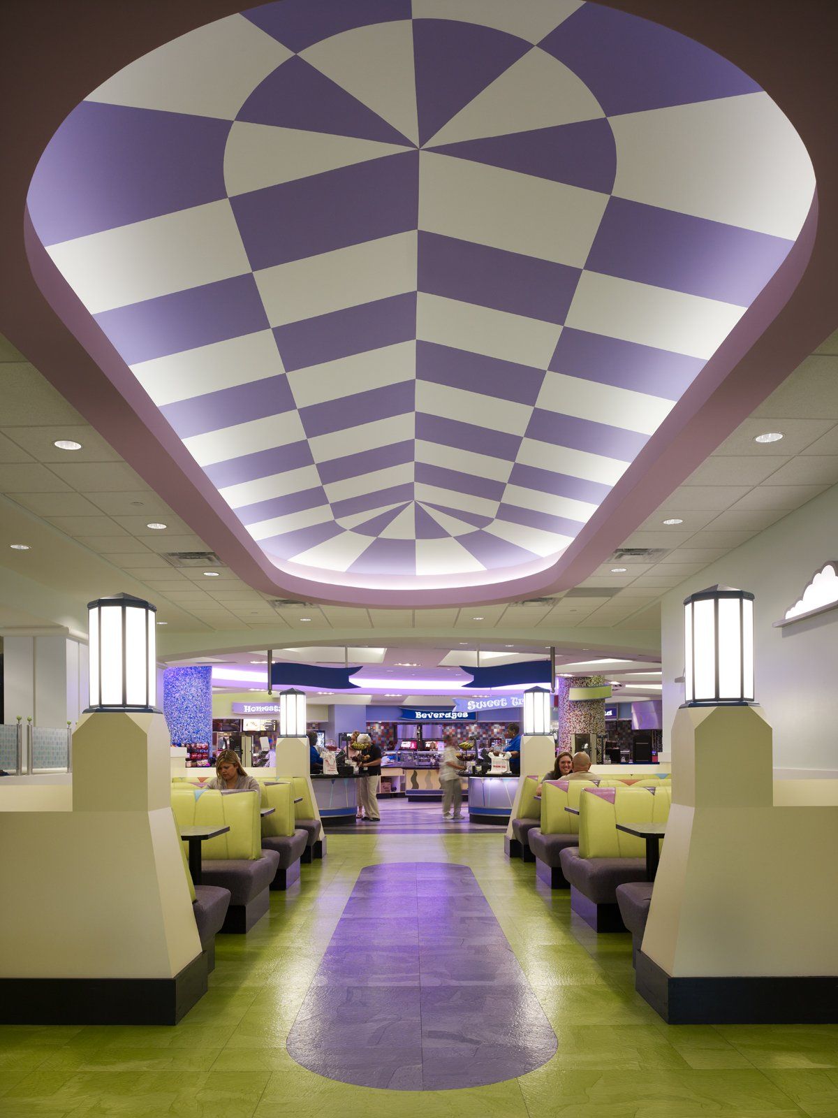 A retro-style diner interior with a checkered purple and white ceiling, booths, and a green floor.