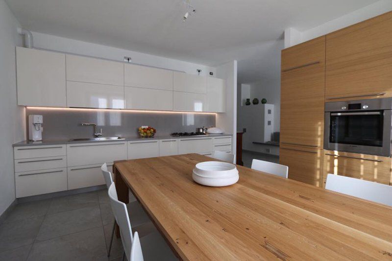 tavolo in legno in cucina con mobili bianchi