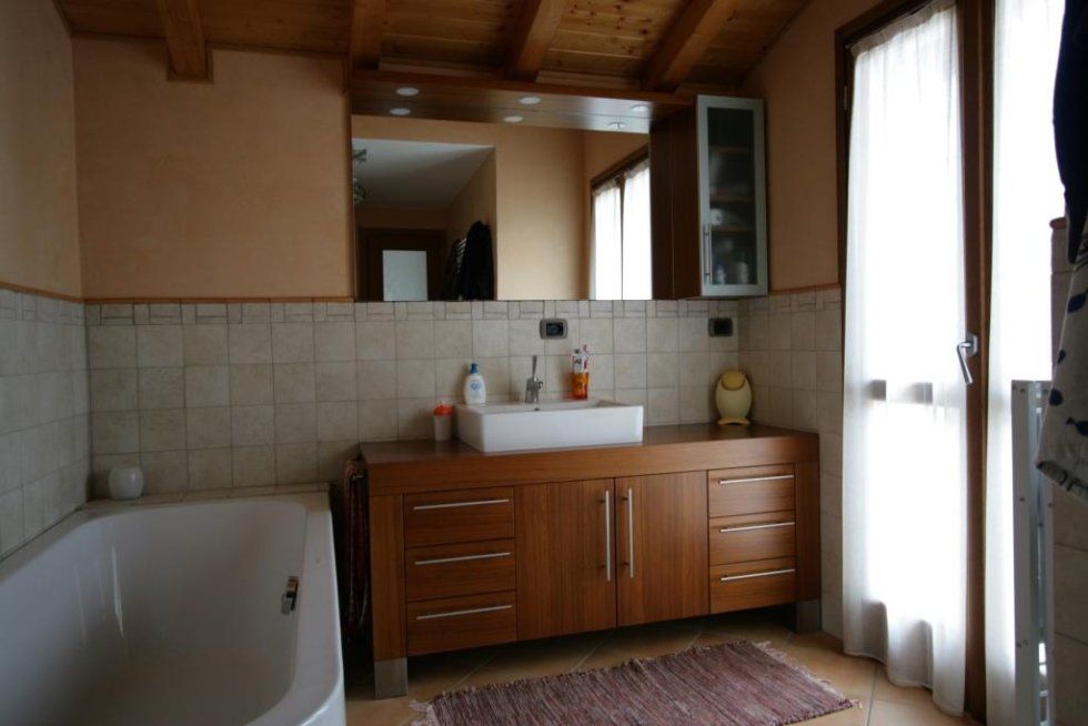 bagno con vasca e mobile in legno