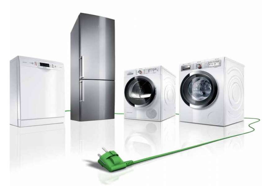 Elettrodomestici con spina verde: lavastoviglie, frigorifero, lavatrice e forno collegati tramite un cavo di alimentazione