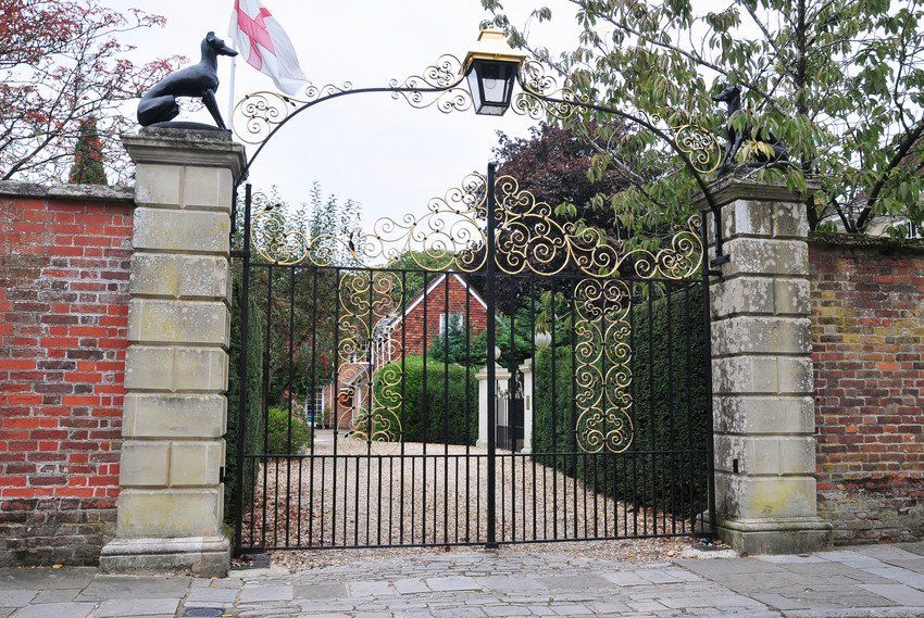 A gate with a statue of a dog on top of it