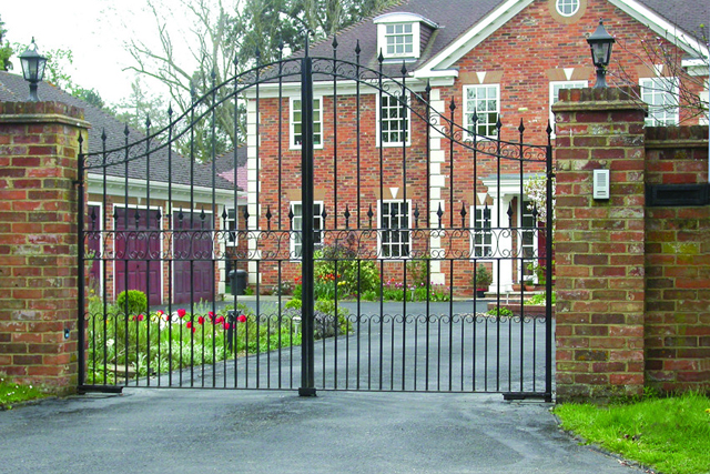 A brick house with a wrought iron gate in front of it