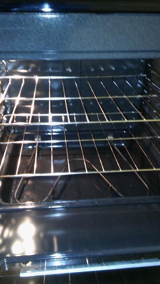 Empty oven with racks visible. Black interior and shiny, metallic racks.