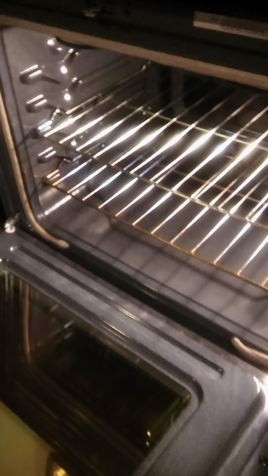 Interior of an oven with metal racks. Light shines on the racks from an unknown source.