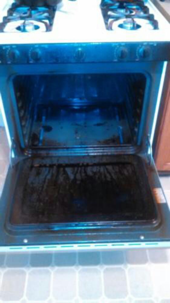 Dirty oven interior with opened door, showing baked-on grime and grease.