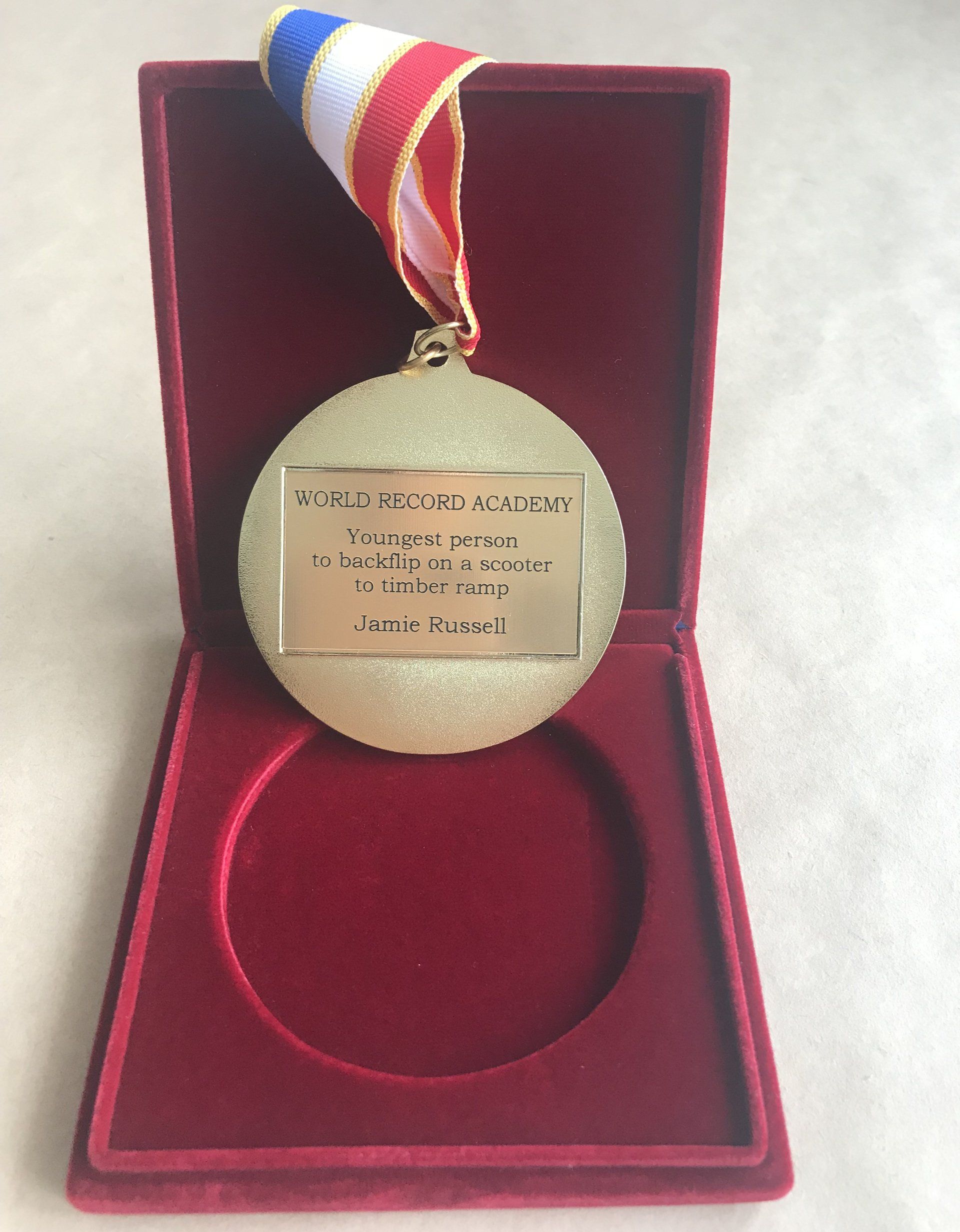 medal for the Youngest person to back flip on a scooter to timber ramp: world record set by Jamie Russell