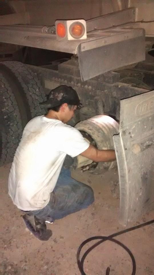 diesel mechanic at work on wheel well