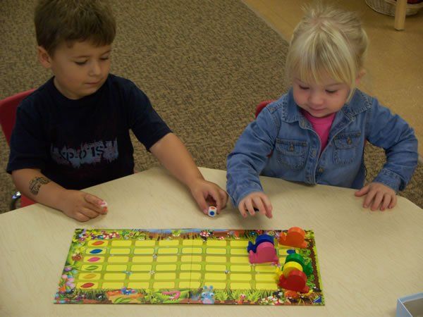 A boy and a girl are playing a board game