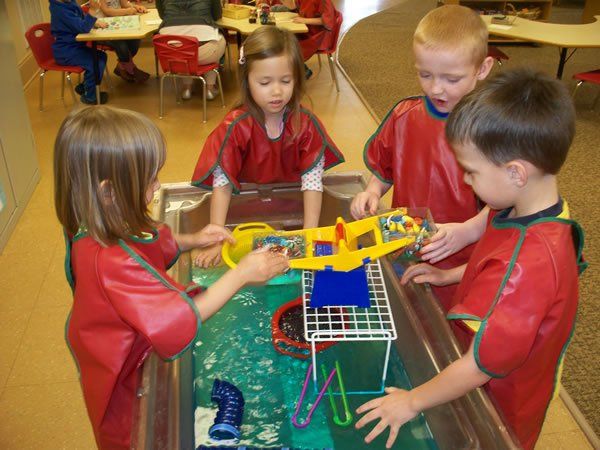 A group of children are playing with toys on a table