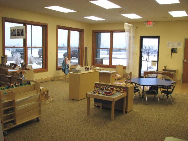 A room with tables and chairs and a red exit sign