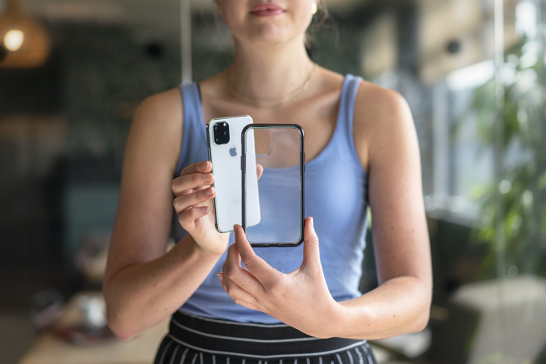 A woman is holding a case and cellphone in her hands