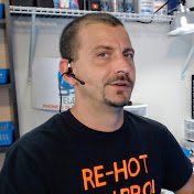 Un hombre vestido con una camiseta negra y unos auriculares está parado en una habitación.