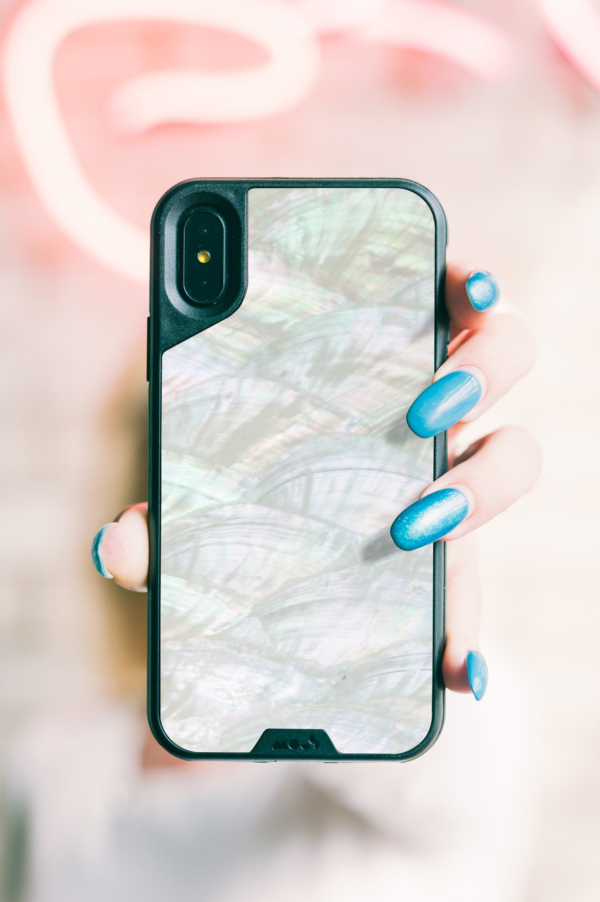 A woman with blue nails is holding a cell phone in a case.
