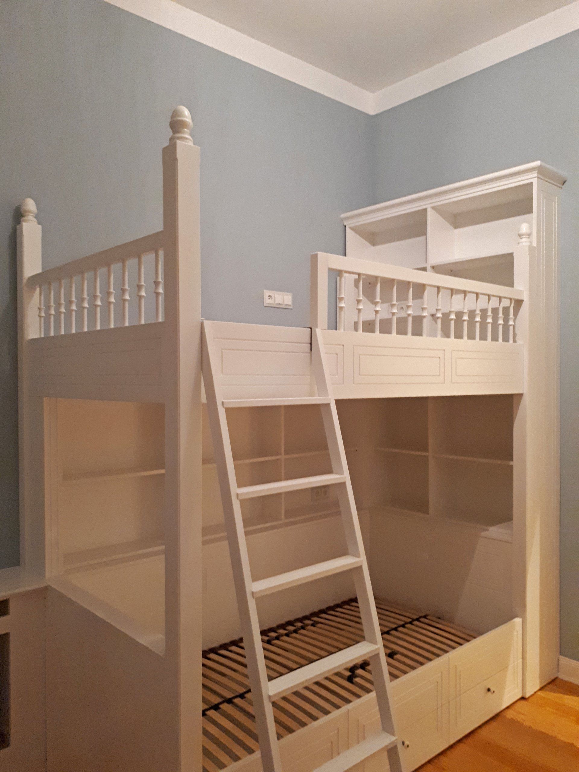 Ein weißes Etagenbett mit einer Leiter in einem Zimmer