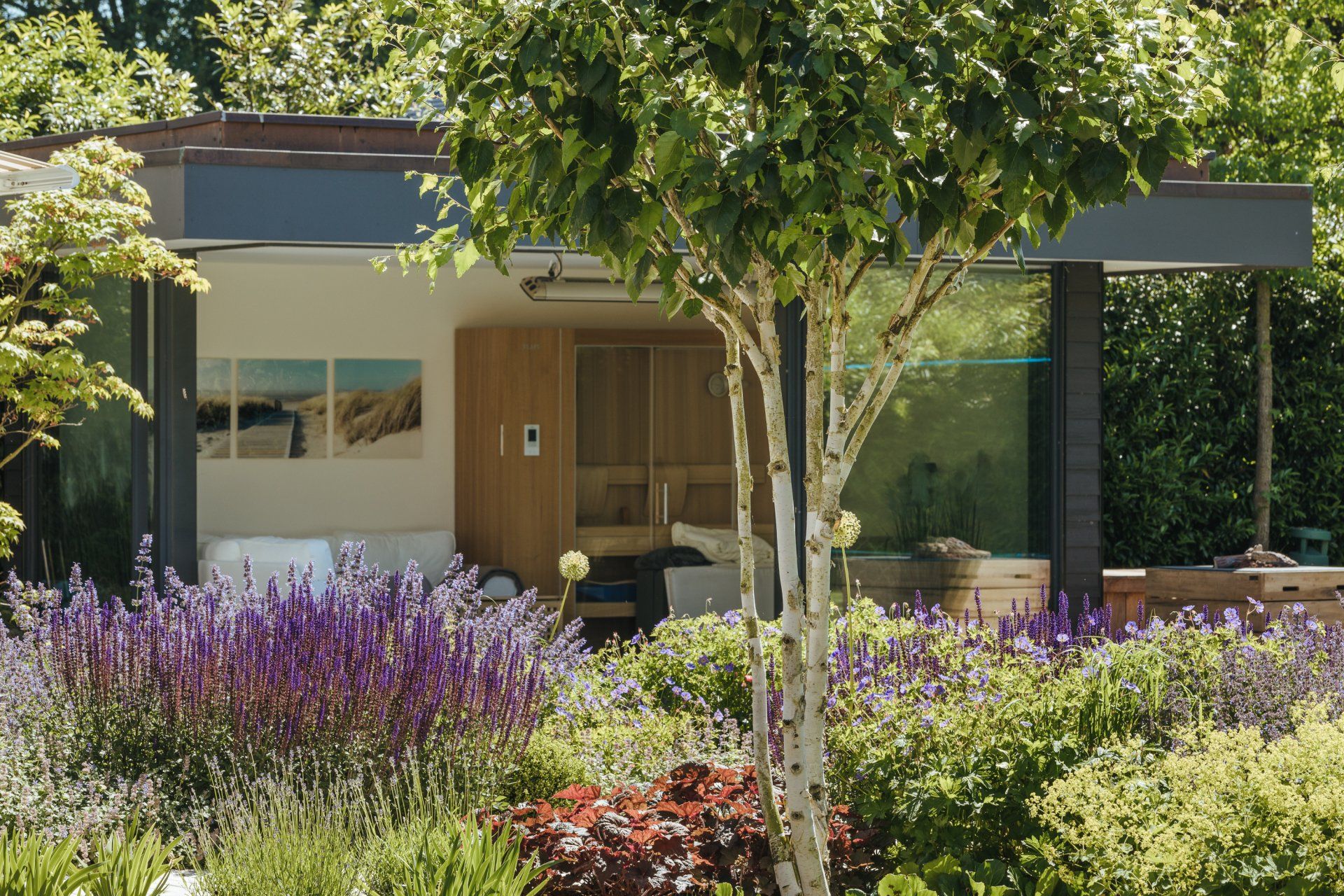 Ein Haus mit lila Blumen und Bäumen davor