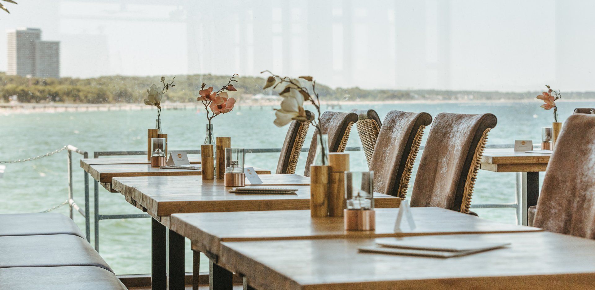 Ein Restaurant mit Tischen und Stühlen mit Blick auf den Ozean.