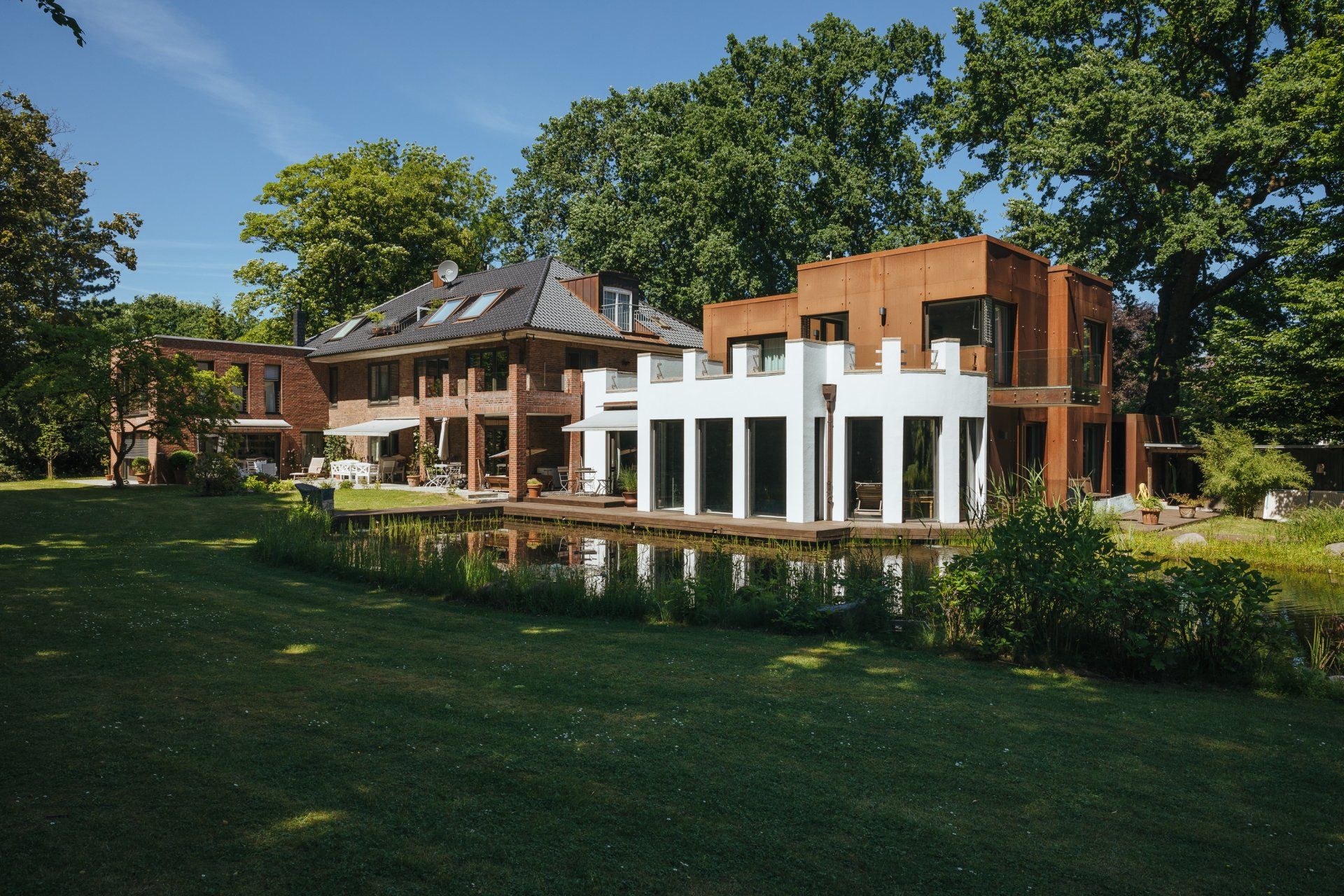Ein großes Haus mit einem Teich davor