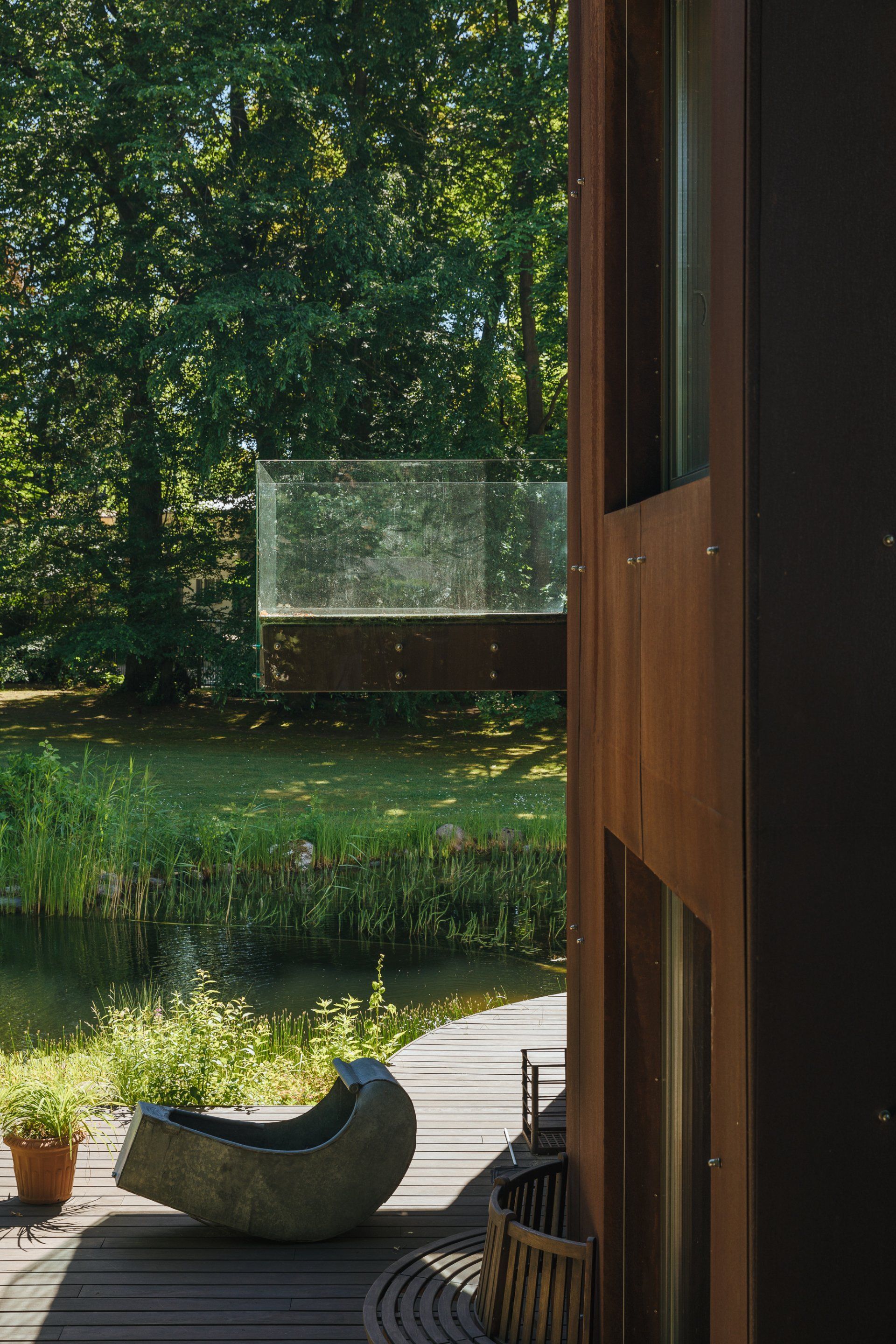 Ein Stuhl steht auf einer Terrasse neben einem Teich.