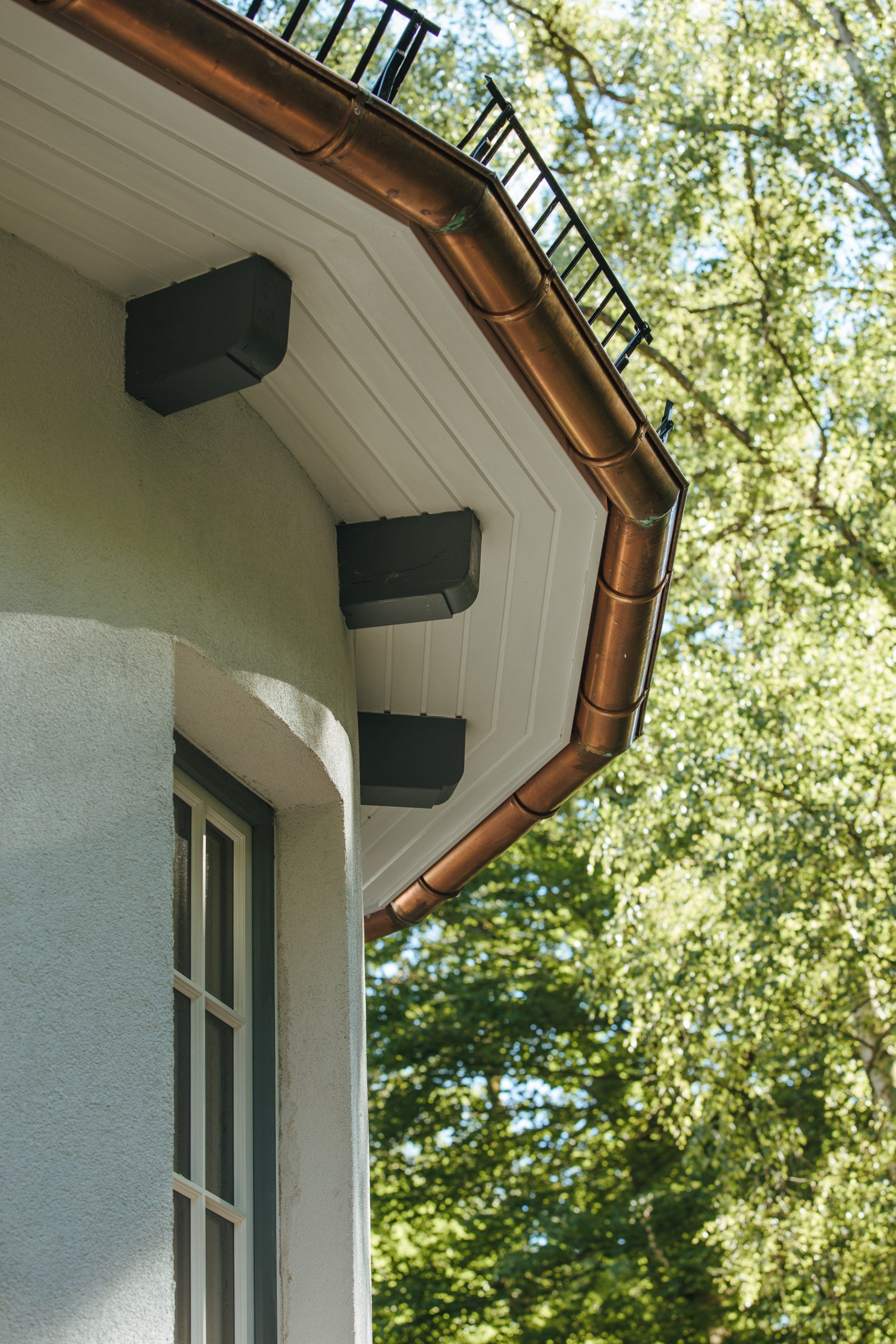 Ein Haus mit einer Kupferdachrinne an der Seite.
