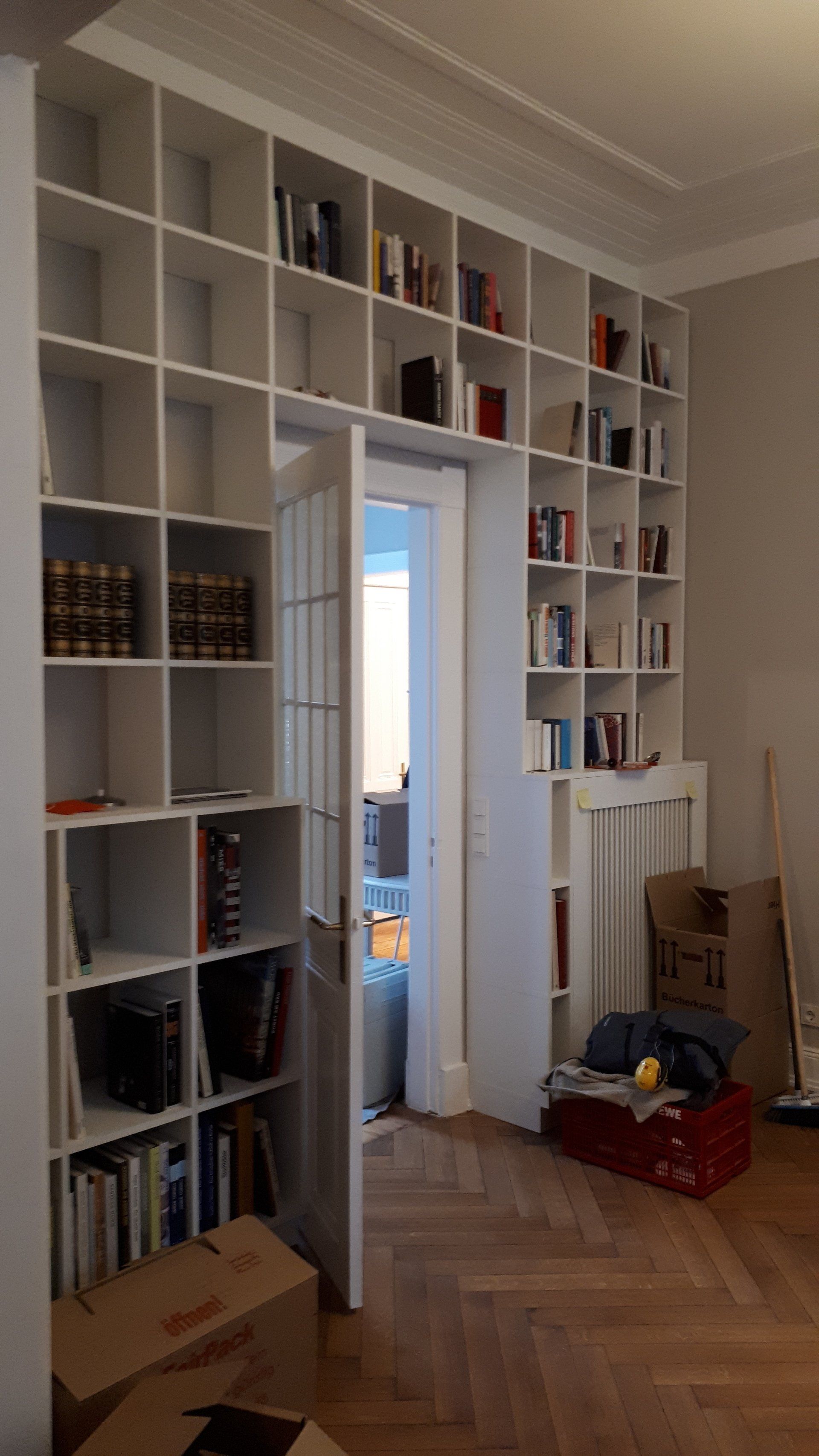 Ein Raum mit vielen Büchern in Regalen und Kisten auf dem Boden