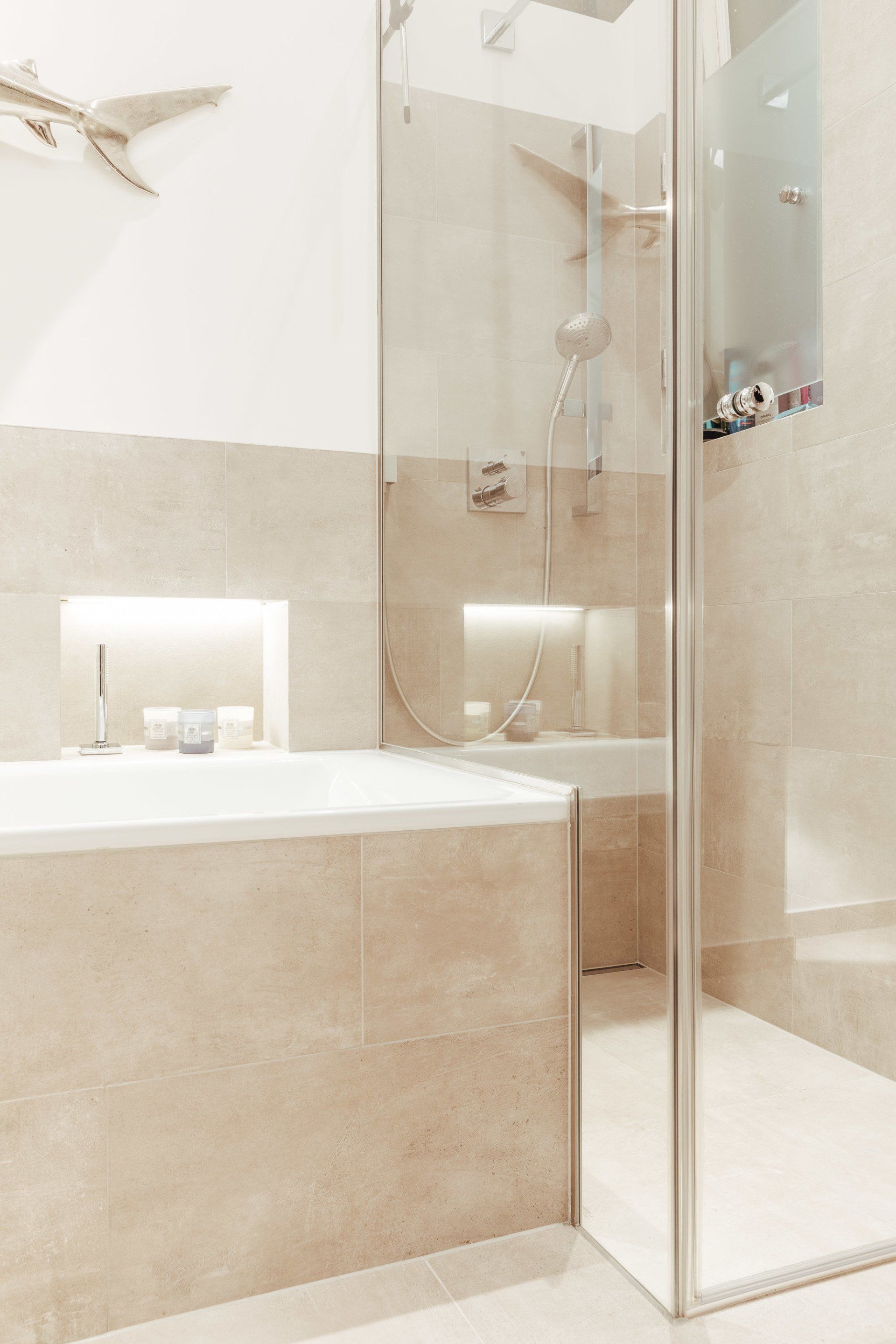 Ein Badezimmer mit Badewanne und ebenerdiger Dusche.