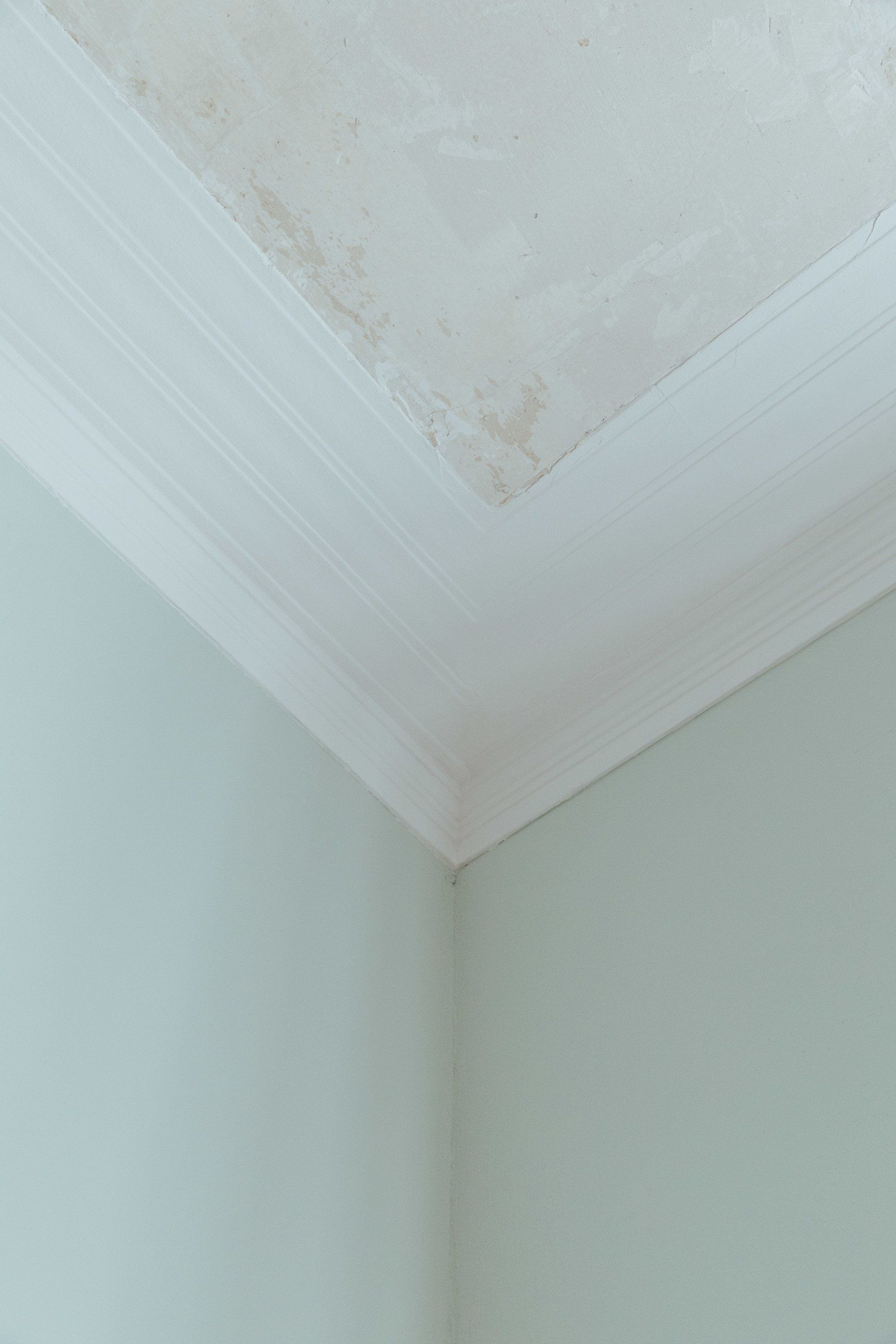 Eine Nahaufnahme einer Raumecke mit Decke und Wänden.